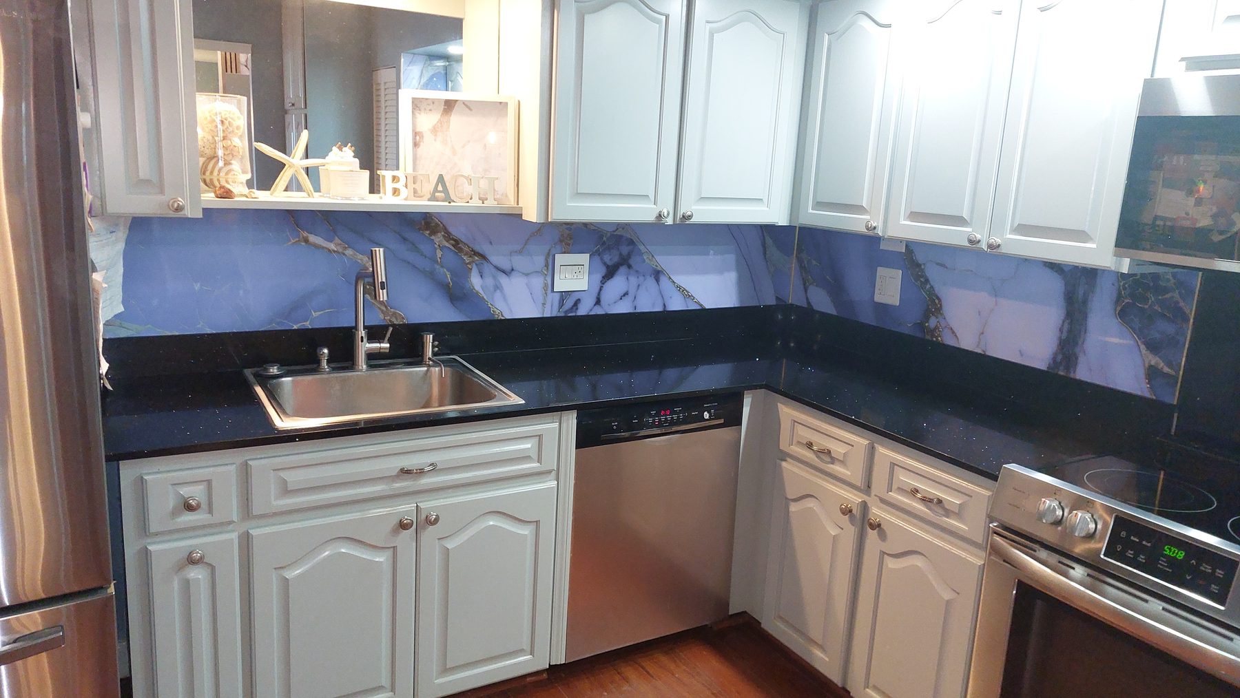 Close-up of marble style backsplash with black counters