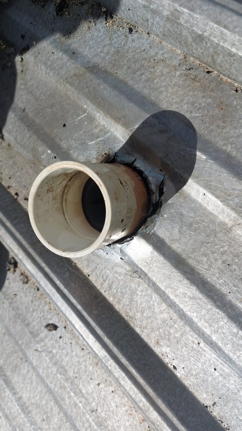 Leaking pipe boot on metal roof before repair