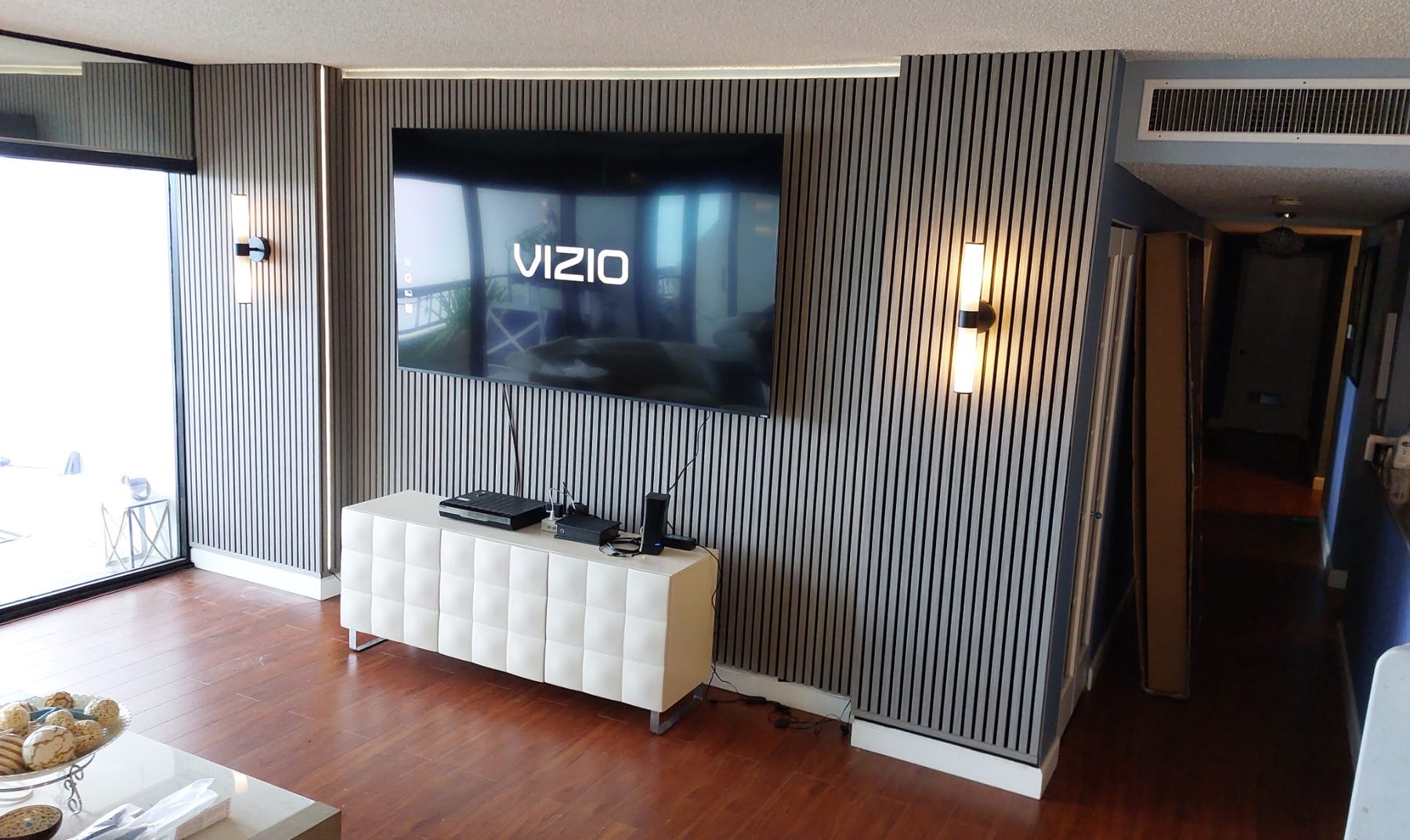 Living room TV wall after slat panels and LED cove lighting